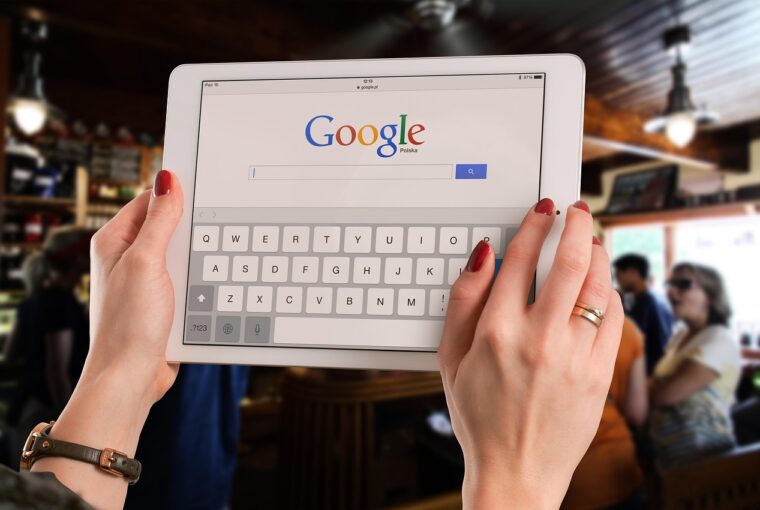 Mãos segurando um tablet com a página de busca do Google aberta, ilustrando o contexto da queixa antitruste contra o Google por uso de IA nos resultados de busca