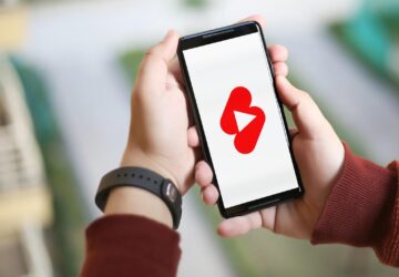 Criança com smartphone e tela do YouTube Shorts