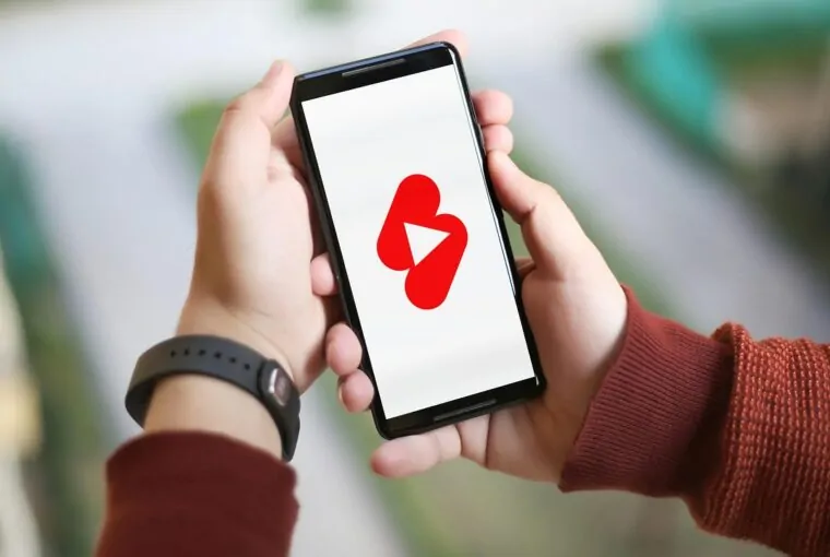 Criança com smartphone e tela do YouTube Shorts