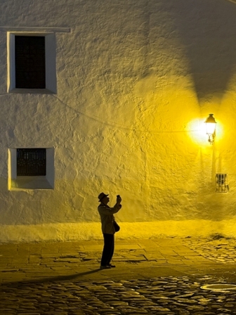Homem parada em uma rua em frente a um lampião em Villa de Leyva, Colômbia. A imagem ganhou o grande prêmio do concurso de fotografia com iPhone