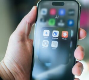 Mão segurando smartphone mostrando ícones de atalho para ferramentas de IA Inteligência artificial