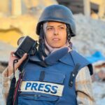 Jornalista palestina Mariam Abu Dagga usando colete de imprensa azul, jvítima em ataque de Israel ao Hospital Nasser