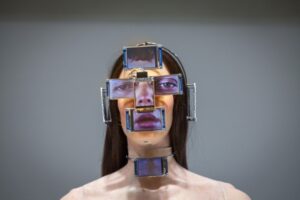 Escultura de mulher com telas de LED no rosto, cabeça e pescoço. A imagem faz parte da mostra Beleza Virtual