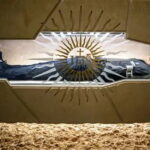 Santo Carlo Acutis em sua tumba em Assis usando tênis Nike e moletom North Sails