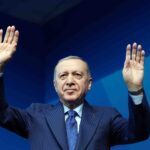 Presidente Erdogan, da Turquia, fazendo discurso com mãos levantadas