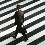 Homem de terno andando em faixa zebrada