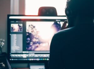 Homem de costas olhando para tela de computador