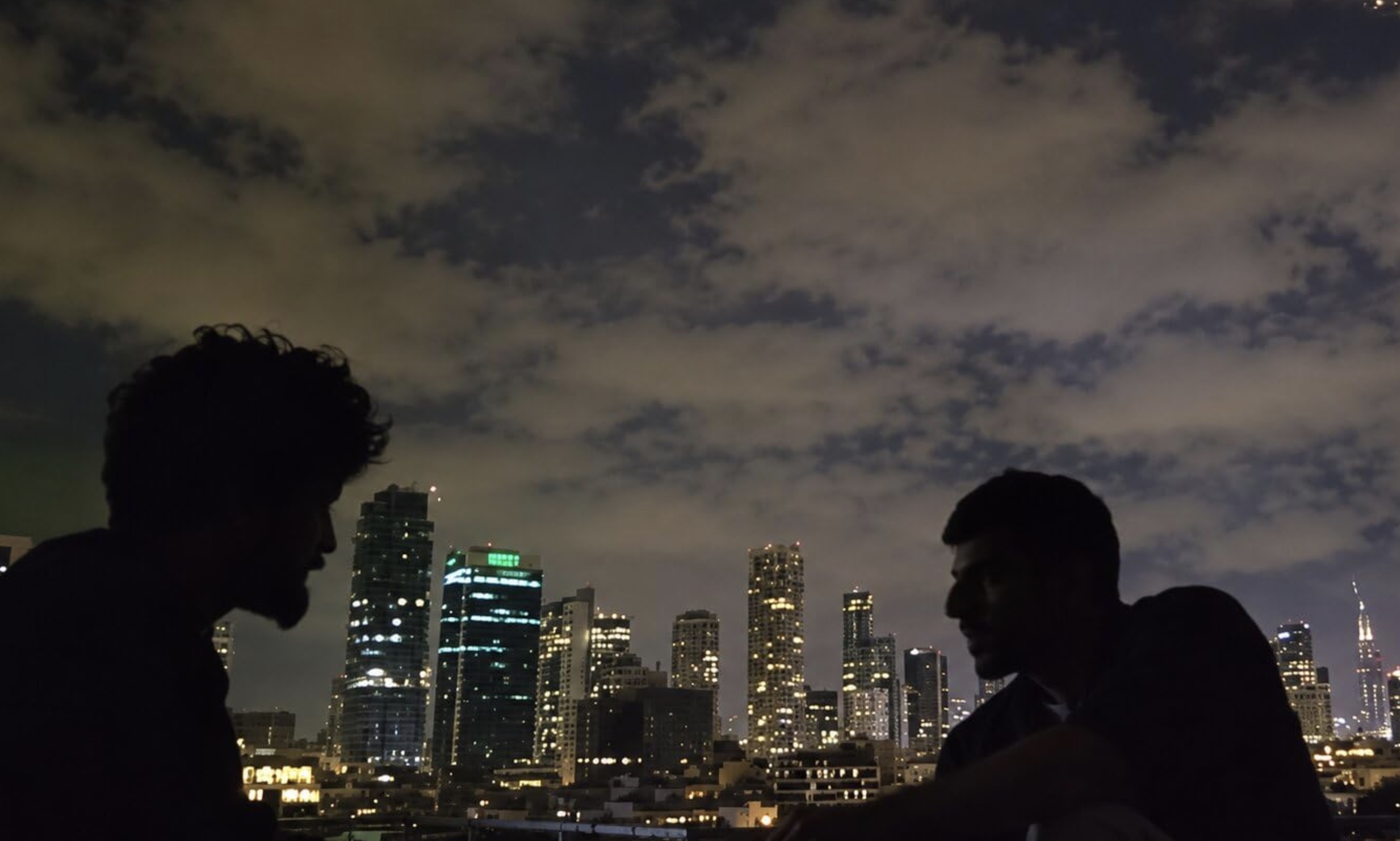 dois homens conversando com cidade ao fundo, cena do documentário NAZA
